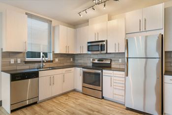a kitchen with white cabinets and stainless steel appliances
